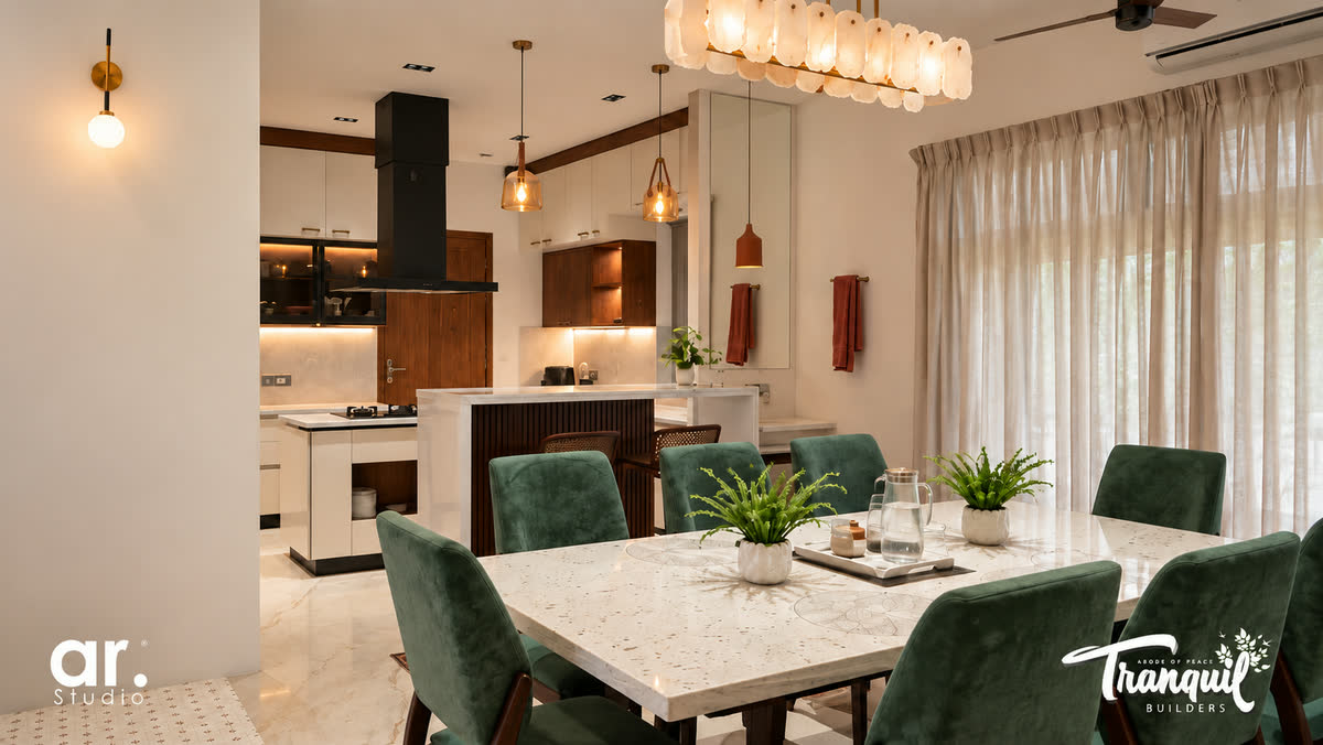 Ajish Residency — the dining table beneath the pendant cluster, open to the kitchen
