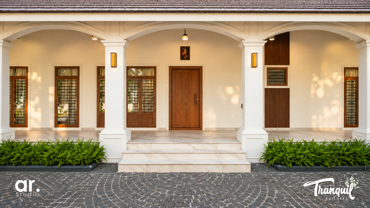Ajish Residency — the entrance portico, columns framing the teak front door