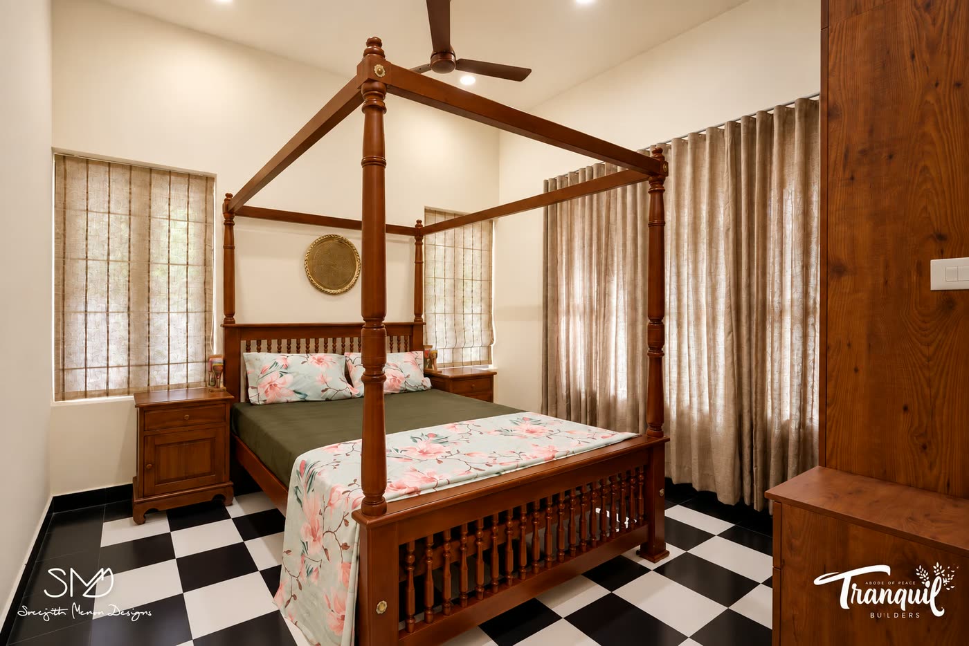 A bedroom with a carved teak four-poster bed on chequered flooring
