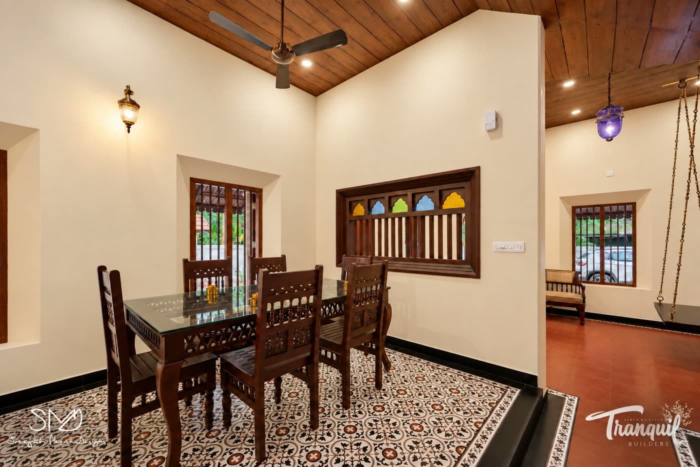 The dining area on patterned cement tile, lit by a coloured-glass lantern